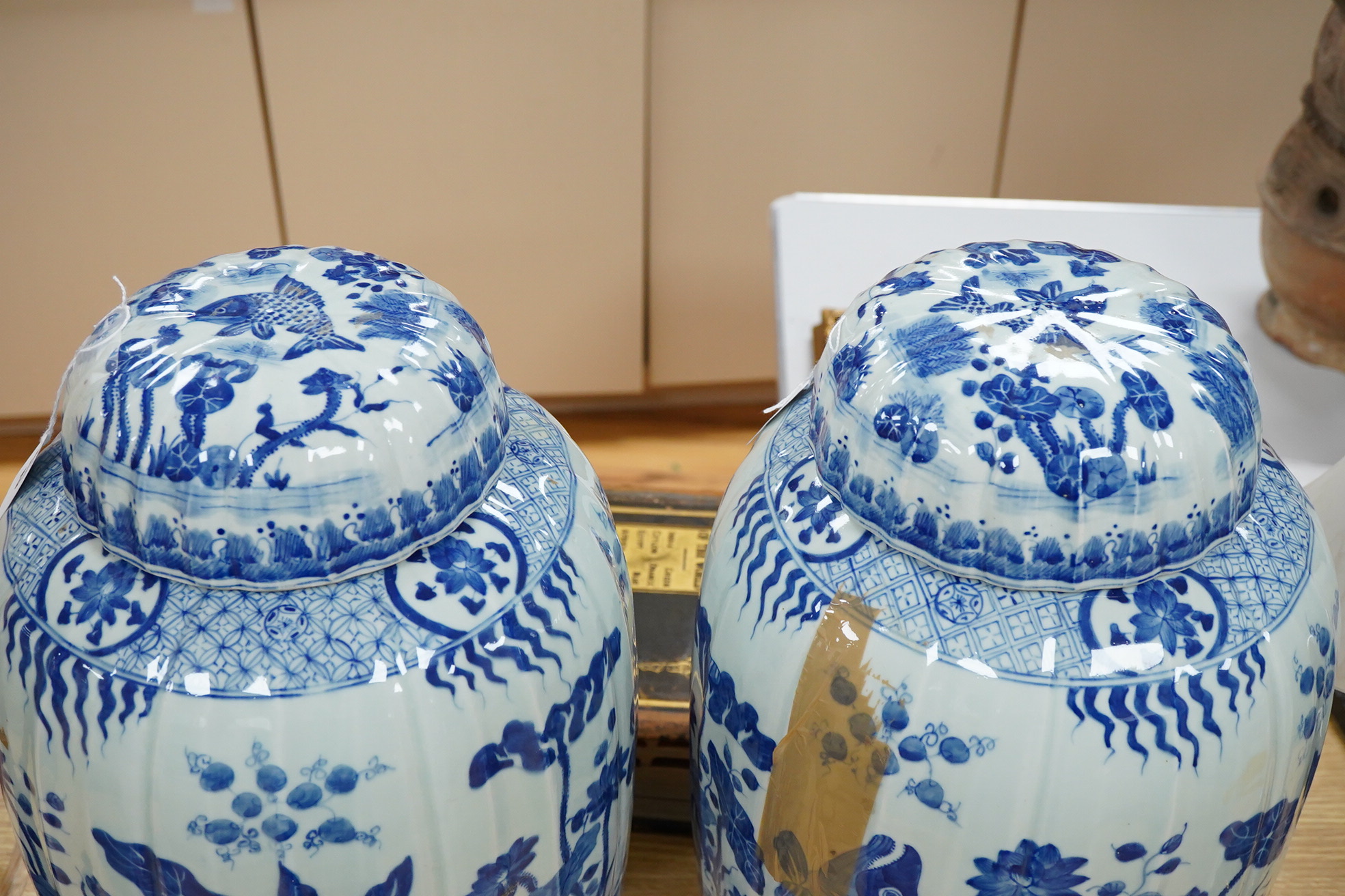A large pair of Chinese blue and white ovoid jars and covers decorated with fish and lotus, 48cm high